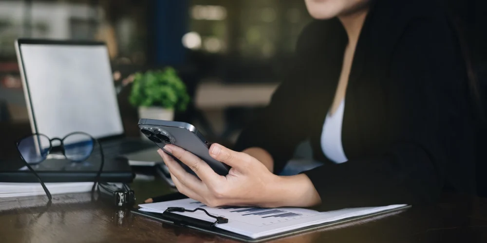 Compliance professional reviewing customer data on a mobile device during KYC remediation to verify and update client information