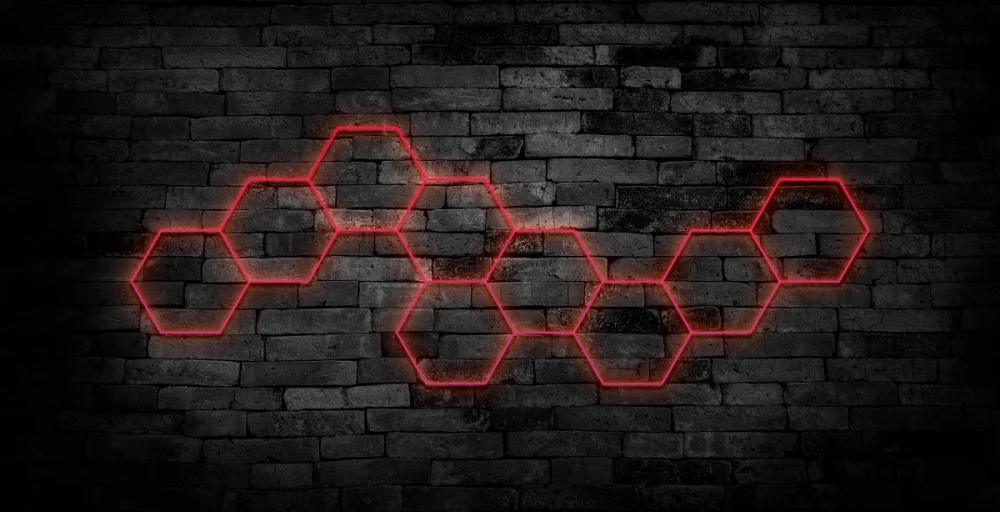 Red glowing hexagonal network pattern on a dark brick wall, illustrating blockchain technology or decentralized digital systems