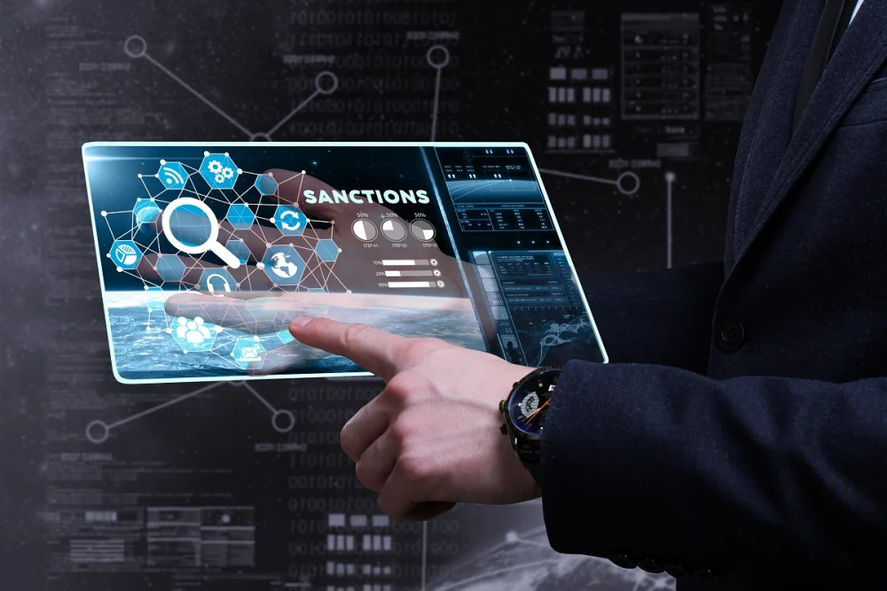 Business professional reviewing digital sanctions data and identity signals on a transparent touchscreen, illustrating KYC best practices for sanctions screening and risk detection